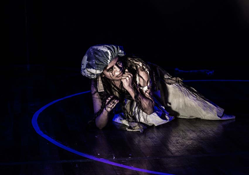 A person crouching on the stage